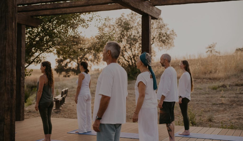 Group of people enjoying the nature while standing in a yoga mat